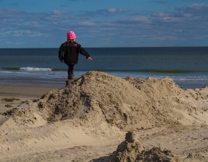 A little girl's innocent play contrasts with Sandy's damage to the beach